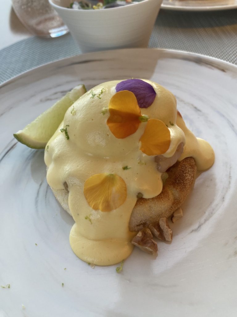 エッグベネディクト 海。海老、ワカモレにオランデーズソース。そこへ胡桃がちりばめられている。ライムを絞ってさっぱりいただく。