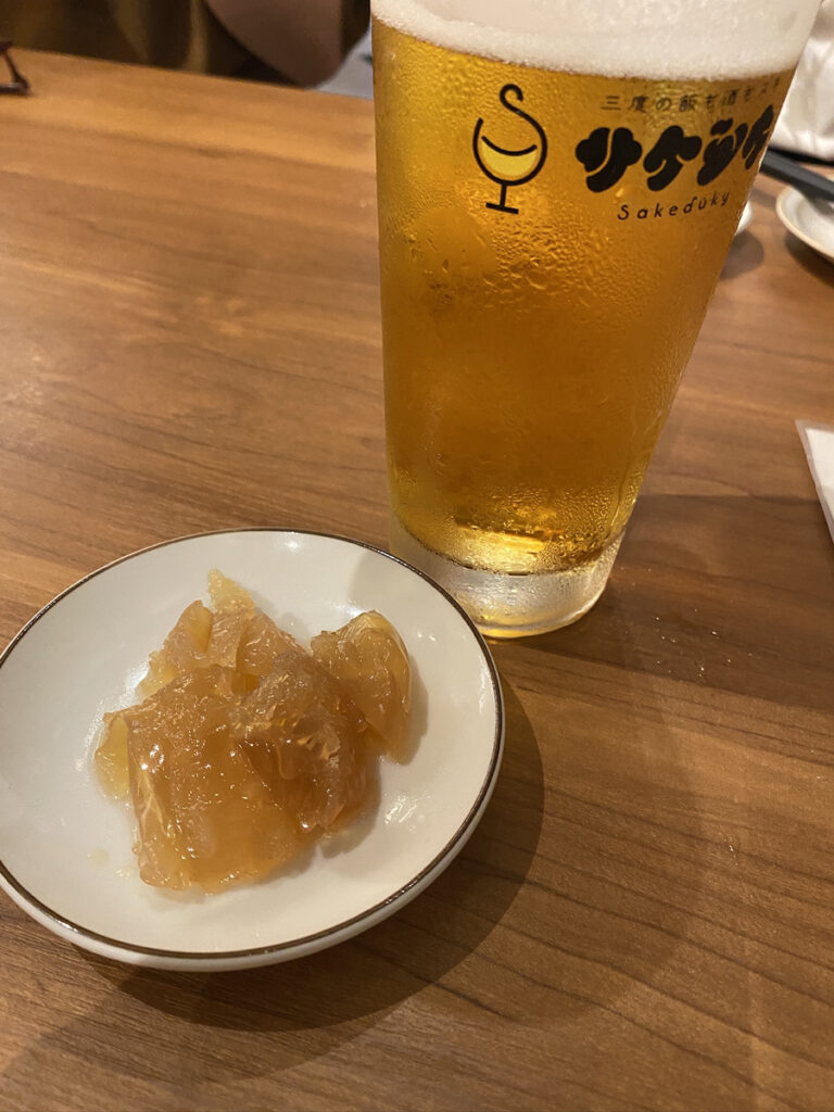 生ビール（おつかれ生です・590円）とつきだしのコリコリくらげ